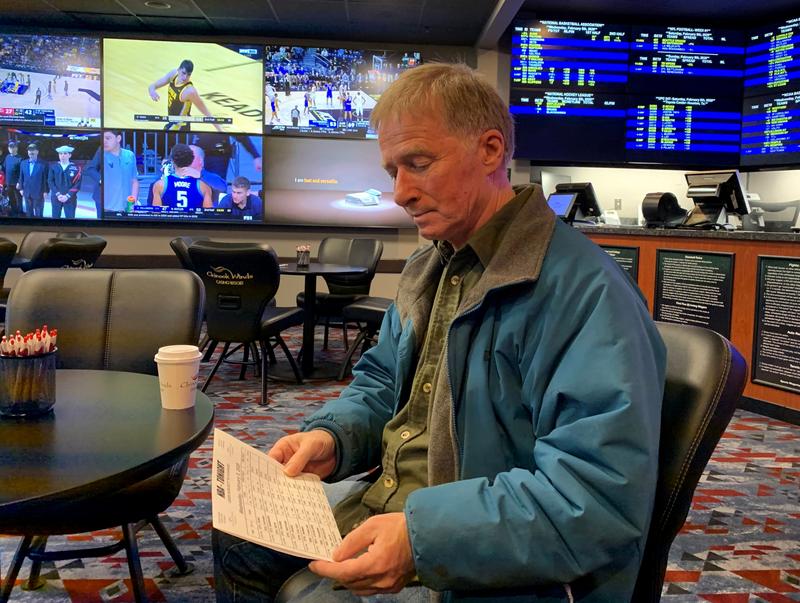 Football and basketball fan David Salisbury studying the daily odds at the Chinook Winds Casino sportsbook in Lincoln City, Oregon.