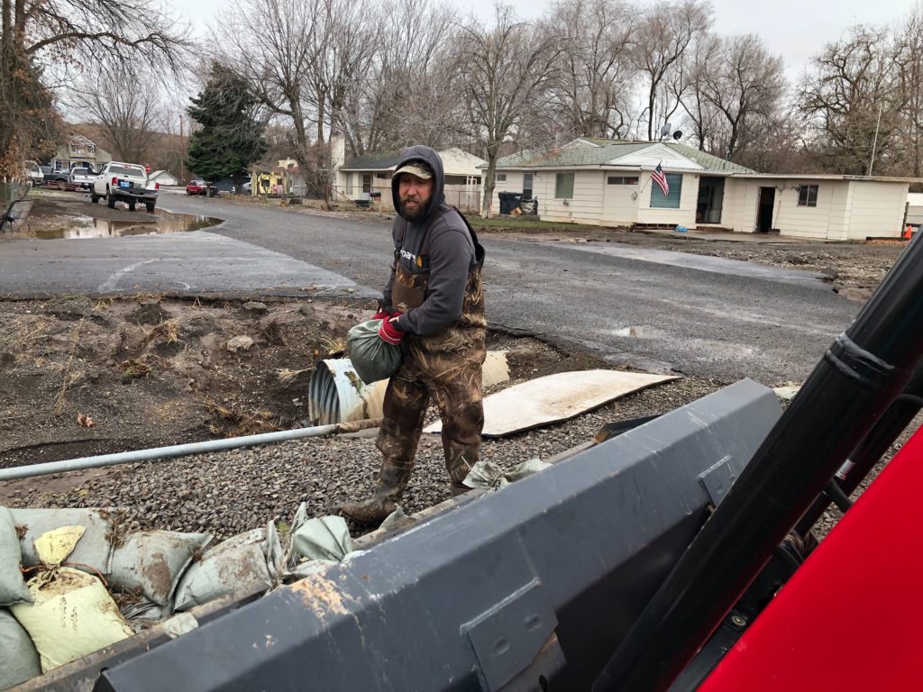 Brandon Cole, of Waitsburg, Washington, helps his neighbors remove sandbags Saturday, Feb. 8, after flooding in his neighborhood off Harmon Road.