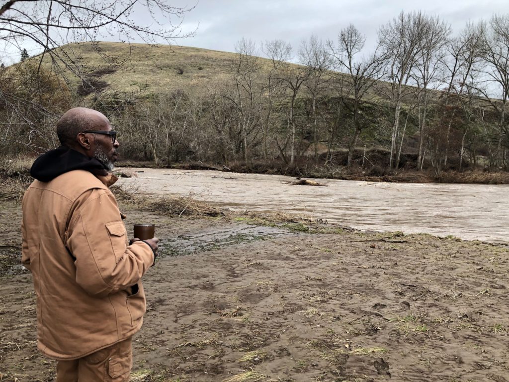 Leroy Cunningham, of Waitsburg, Washington, looks at the Touchet River behind his near century-old farmhouse. Cunningham says he and his husband lost their fine Northwest wine collection in the flooded cellar, but the rest of their property made it.
