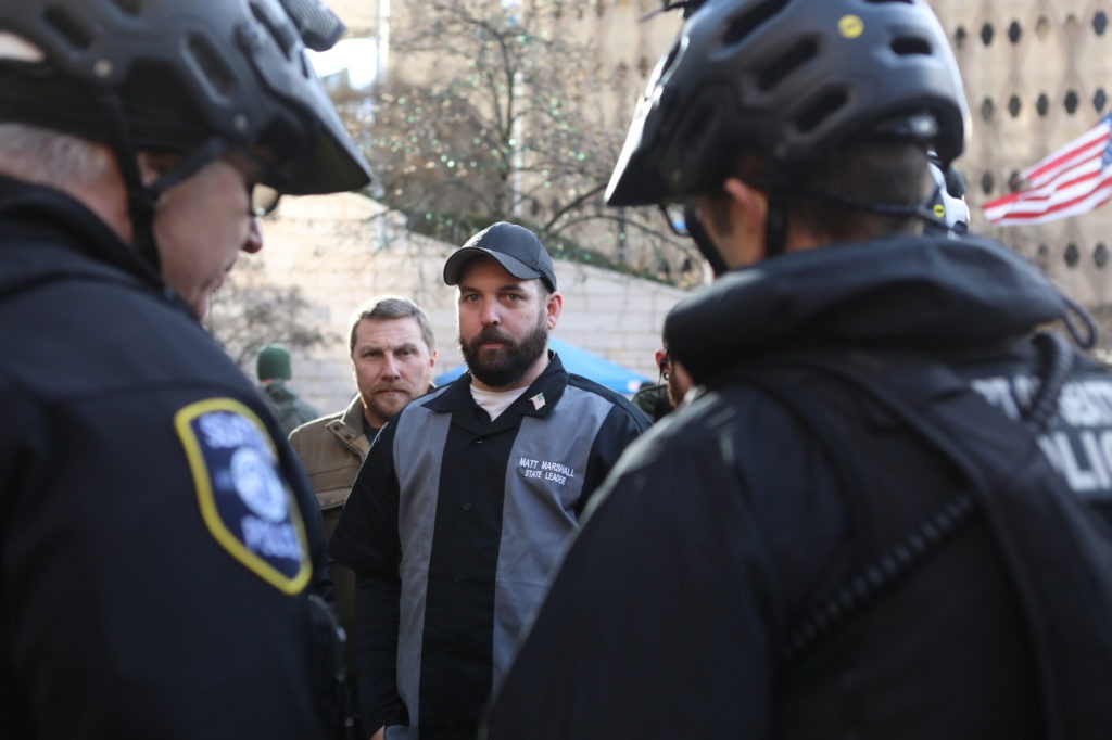 Matt Marshall, state leader of the Washington Three Percent, talks with law enforcement during the rally. He is trying to distance his group from the militia image. CREDIT: Jim Urquhart for NPR