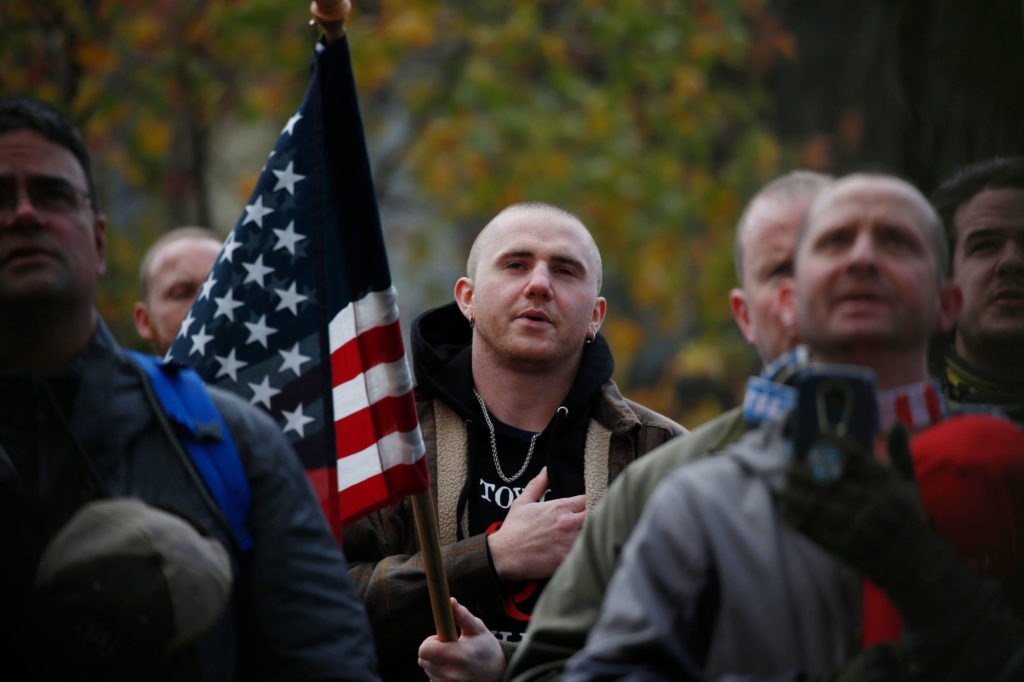 Attendees recite the Pledge of Allegiance during the United Against Hate rally by the Washington Three Percent in Seattle last month. CREDIT: Jim Urquhart for NPR