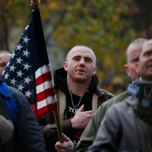 Attendees recite the Pledge of Allegiance during the United Against Hate rally by the Washington Three Percent in Seattle last month. CREDIT: Jim Urquhart for NPR