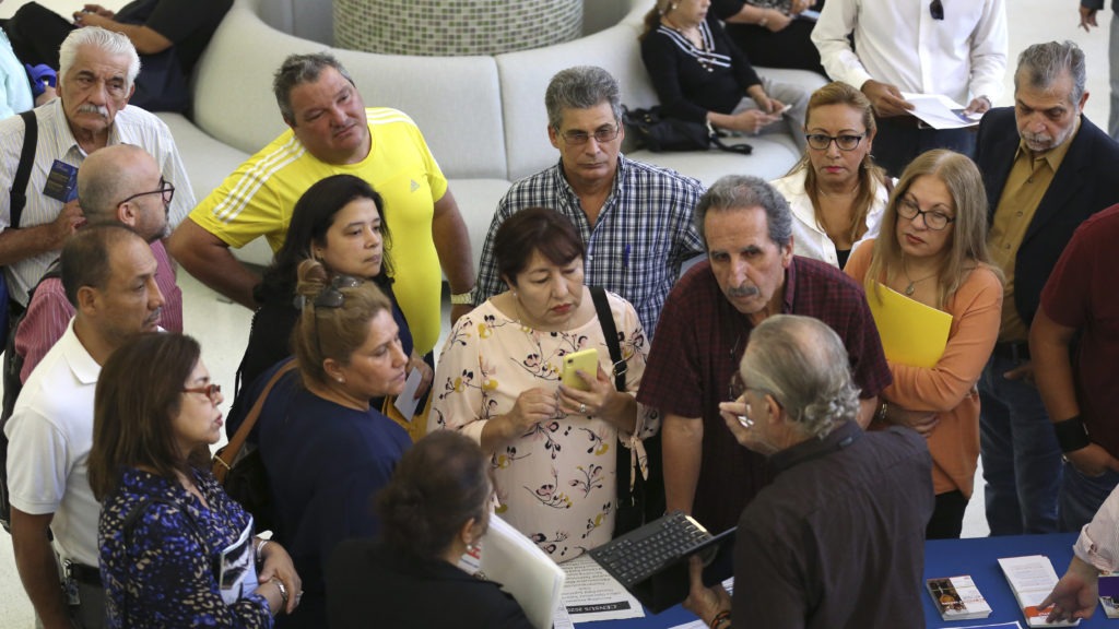 People inquire about temporary positions available for the 2020 census during a job fair in Miami in September 2019. CREDIT: Lynne Sladky/AP