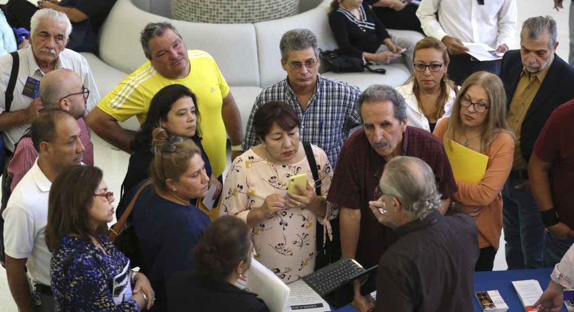 People inquire about temporary positions available for the 2020 census during a job fair in Miami in September 2019. CREDIT: Lynne Sladky/AP