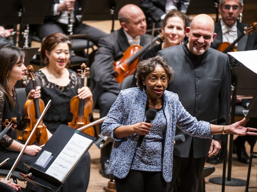 Tania León speaks at the premiere of her piece "Stride," one of 19 pieces composed by women that the New York Philharmonic commissioned to celebrate the 100th anniversary of the 19th Amendment. CREDIT: Chris Lee/Courtesy New York Philharmonic