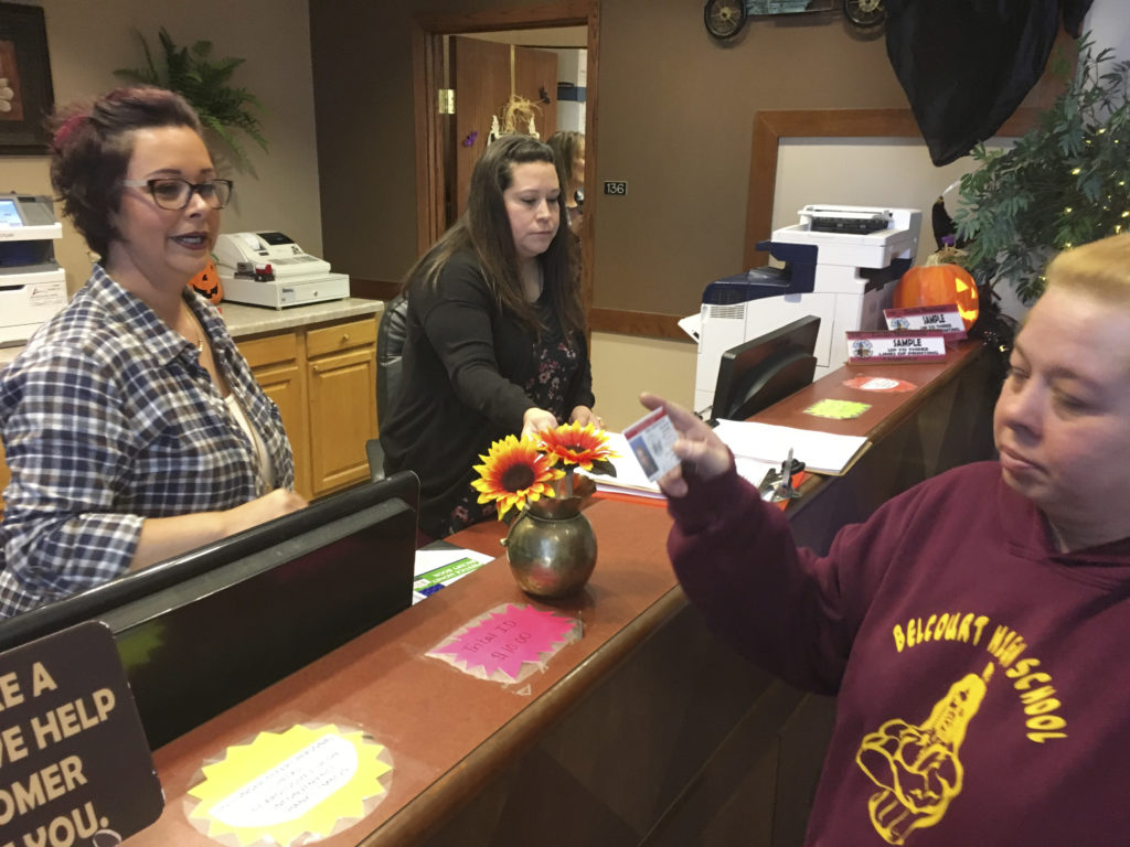 Delaine Belgarde (right) shows the new Turtle Mountain Band of Chippewa identification card, in Belcourt, N.D., in 2018. CREDIT: Blake Nicholson/AP