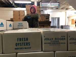Amy Skillings of Oysterville, Washington, wheels the day's shucked oysters into a large cooler to await pickup. The oysters will be flown quickly across the country and to China.