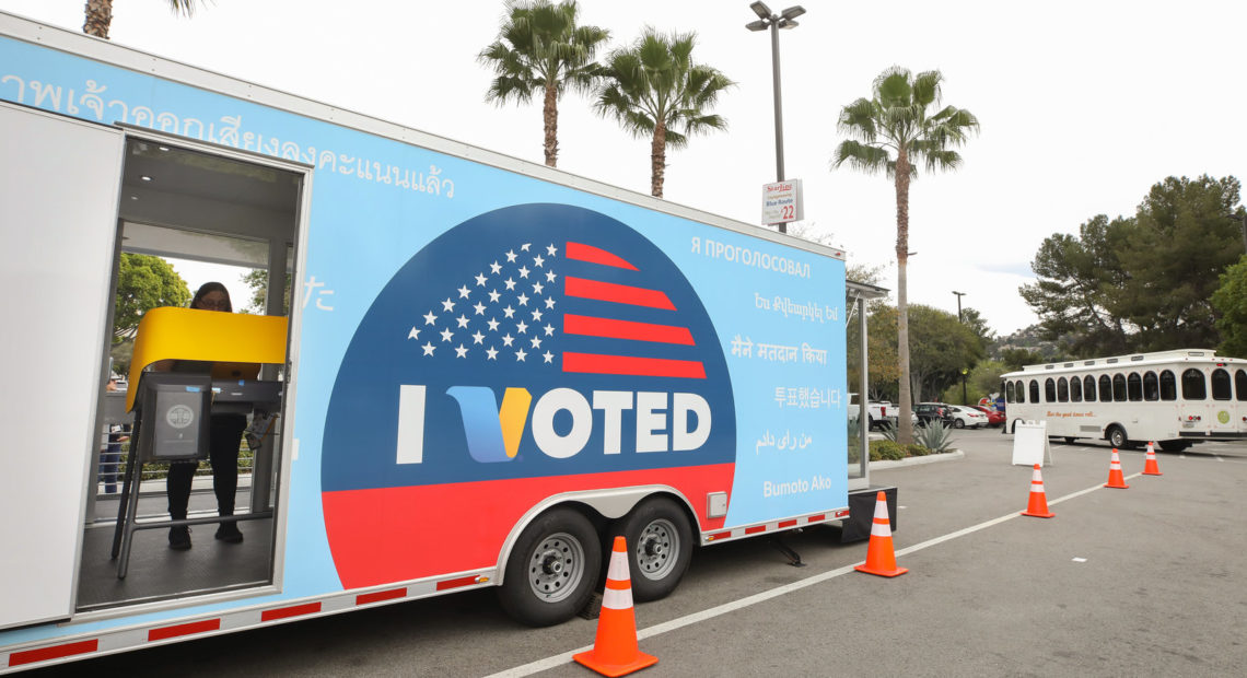 A voter prepares her ballot during early voting for the California presidential primary election at a new LA County "Mobile Vote Center" outside Universal Studios Hollywood on Thursday. Large numbers of Californians vote early and by mail, which can slow election night vote counting. CREDIT: Mario Tama/Getty Images