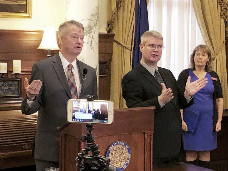 Idaho Gov. Brad Little, left, announces stricter guidelines for social interactions to slow the spread of the new coronavirus, and also livestreaming the discussion, at his office in Boise on March 18, 2020. CREDIT: Keith Ridler/AP