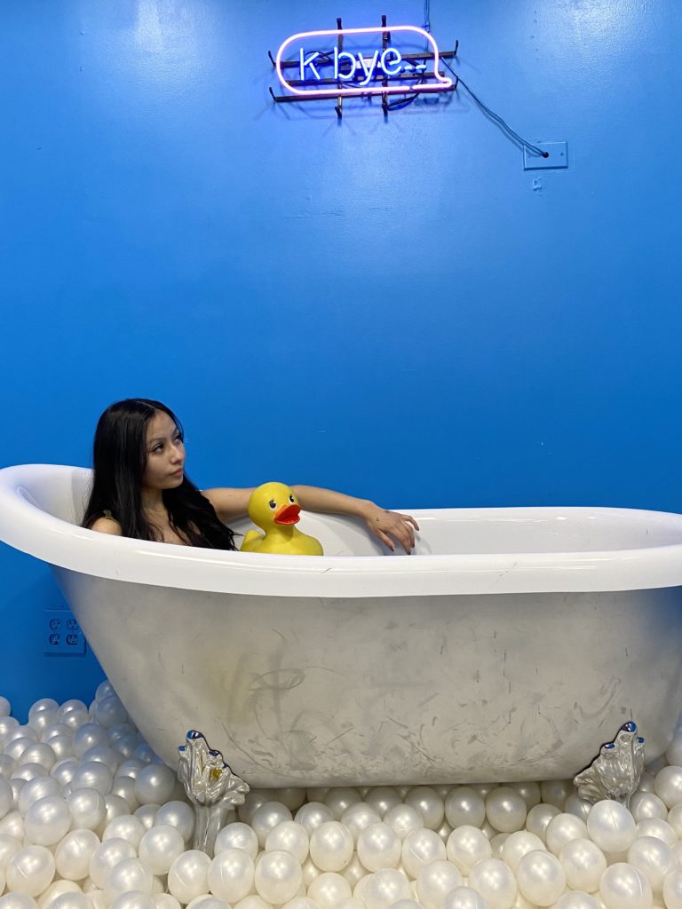 Jubilee Calles is immersed in the bathtub art installation at the Seattle Selfie Museum.