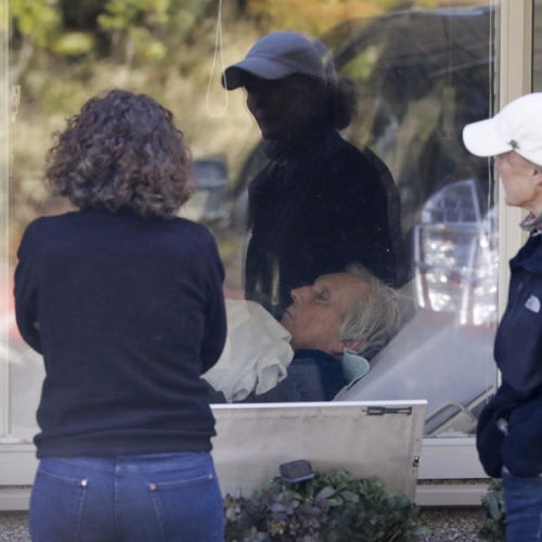 Sisters Seri Sedlacek, left, and Susan Simpkins look in on their father, Chuck Sedlacek, at the Life Care Center, Wednesday, March 18, 2020, in Kirkland. Shuksan Healthcare Center in Bellingham is working to avoid what happened at the Kirkland facility. CREDIT: Elaine Thompson/AP