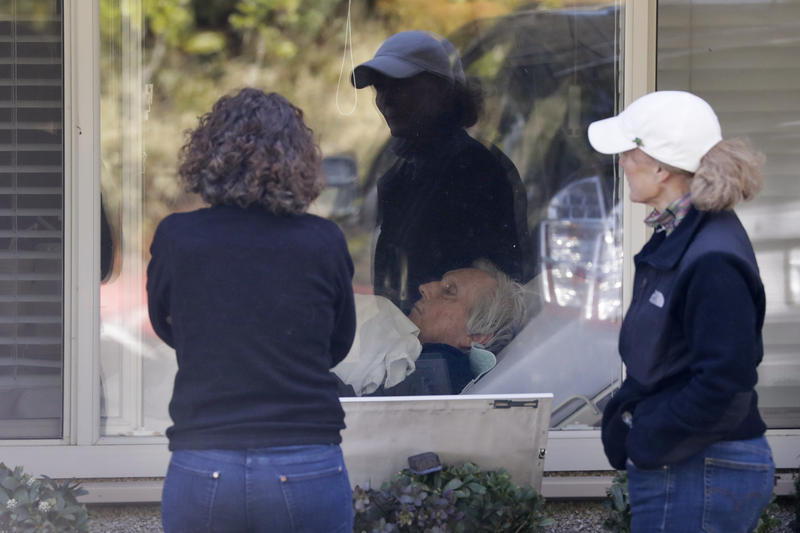 Sisters Seri Sedlacek, left, and Susan Simpkins look in on their father, Chuck Sedlacek, at the Life Care Center, Wednesday, March 18, 2020, in Kirkland. Shuksan Healthcare Center in Bellingham is working to avoid what happened at the Kirkland facility. CREDIT: Elaine Thompson/AP