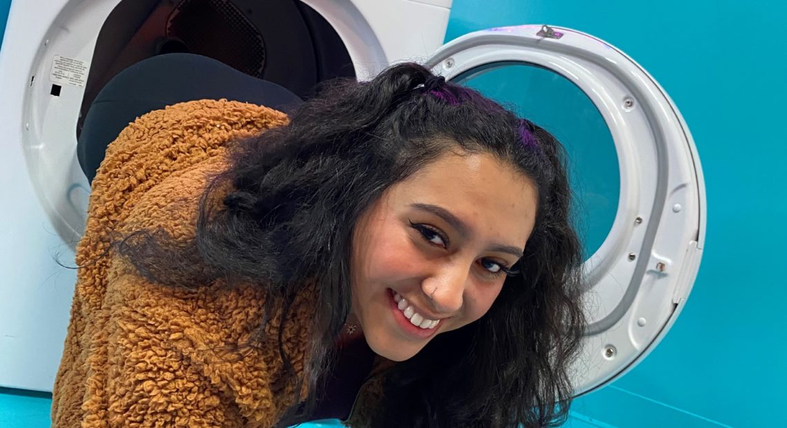 Tali Calles falls out of washing machine art installation at Seattle Selfie Museum.