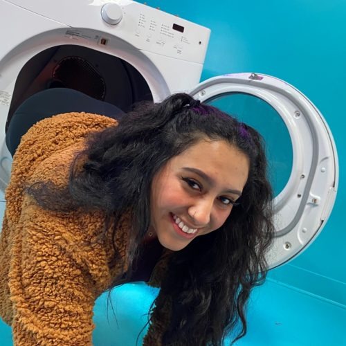 Tali Calles falls out of washing machine art installation at Seattle Selfie Museum.
