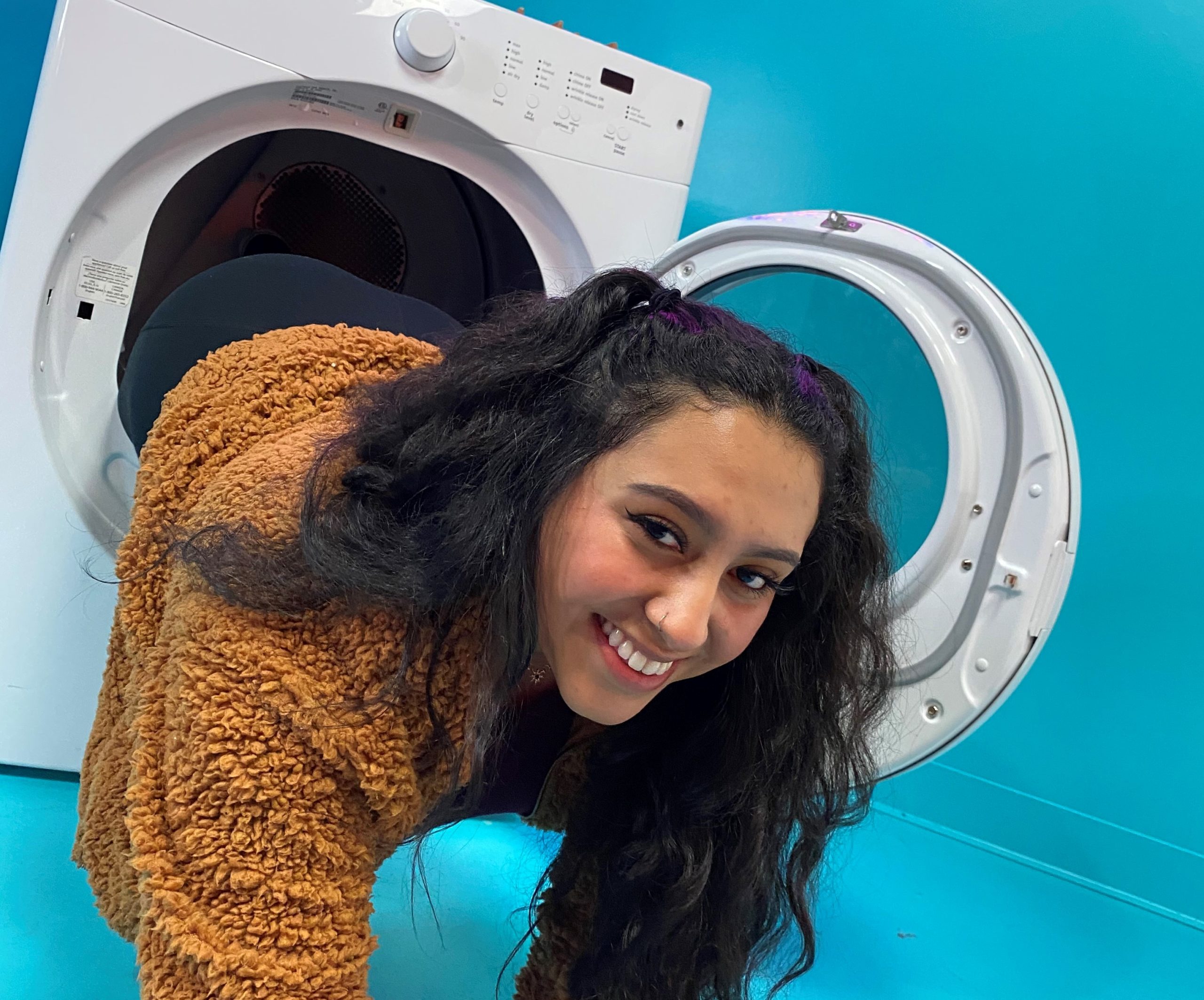 Tali Calles falls out of washing machine art installation at Seattle Selfie Museum.