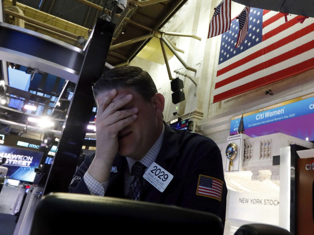 A trader reacts on the floor of the New York Stock Exchange on Monday. Major U.S. stock indexes plunged 7% before trading was temporarily halted. Richard Drew/AP