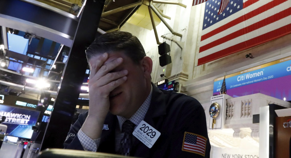 A trader reacts on the floor of the New York Stock Exchange on Monday. Major U.S. stock indexes plunged 7% before trading was temporarily halted. Richard Drew/AP