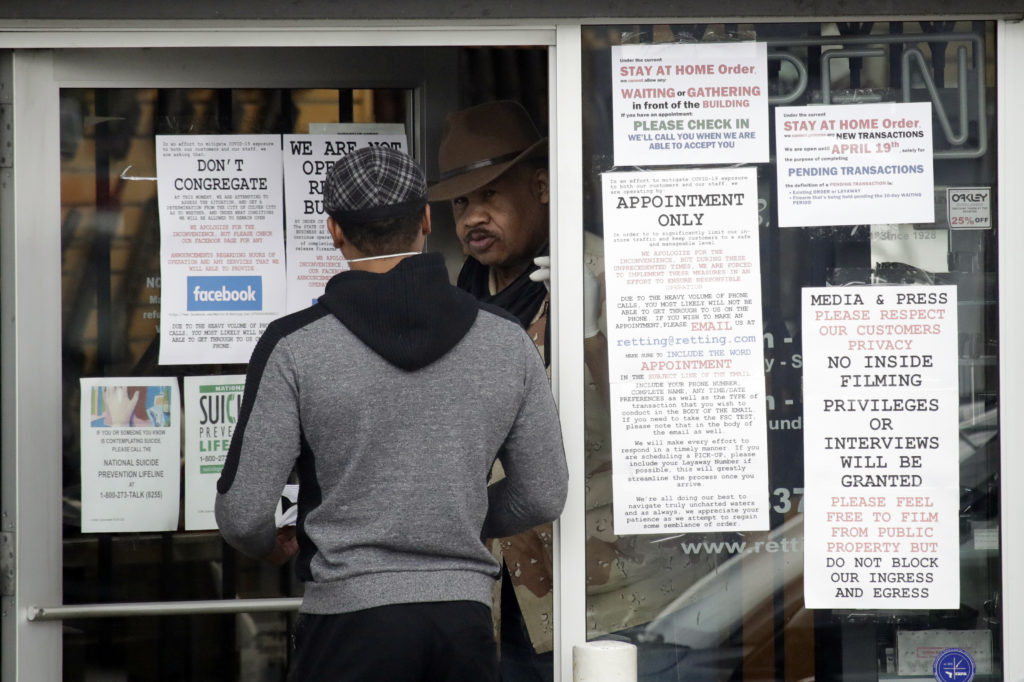 An employee answers questions at the entrance to a gun shop Tuesday in Culver City, Calif. CREDIT: Marcio Jose Sanchez/AP