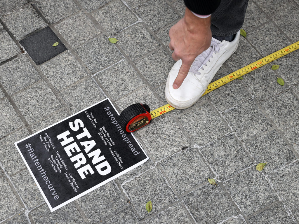 Workers use a tape measure mark spaces six feet apart for people to wait in line safely as they convert the outdoor plaza in front of Zaytinya, one of Chef José Andres' restaurants in Washington, D.C. Efforts to contain the coronavirus are affecting blood donor drives and supplies. CREDIT: Chip Somodevilla / Getty Images