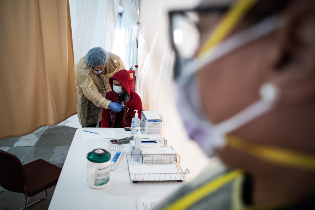 A doctor examines Juan Vasquez as part of a COVID-19 check inside a testing tent outside the emergency department at St. Barnabas Hospital in New York City last week. Misha Friedman/Getty Images