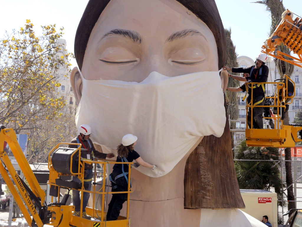 The World Health Organization called the COVID-19 viral disease a pandemic Wednesday. Here, workers in Spain place a medical mask on a figure that was to be part of the Fallas festival in Valencia. The festival has been canceled over the coronavirus outbreak. Alberto Saiz/AP