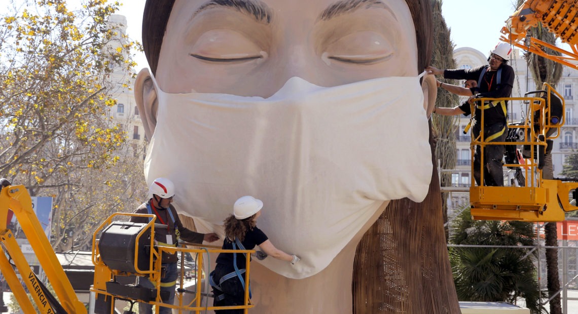 The World Health Organization called the COVID-19 viral disease a pandemic Wednesday. Here, workers in Spain place a medical mask on a figure that was to be part of the Fallas festival in Valencia. The festival has been canceled over the coronavirus outbreak. Alberto Saiz/AP