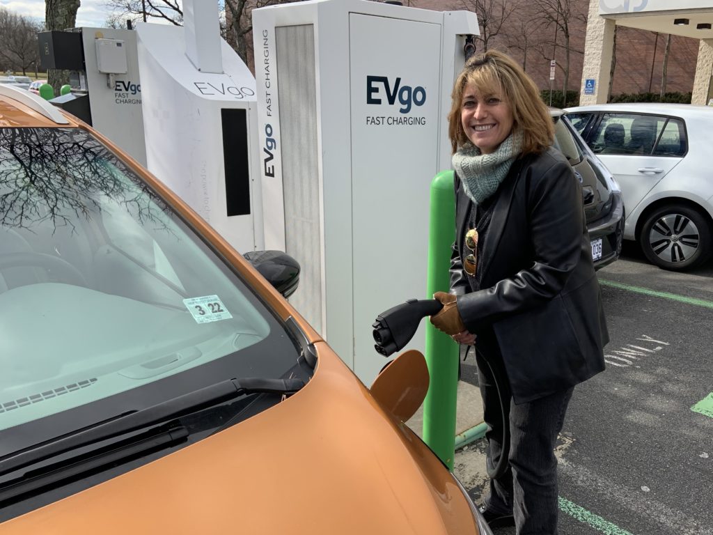 Pam Frank, CEO of ChargEVC, drives a bright Orange Chevrolet Bolt because she wants others to notice its an electric car. Jeff Brady/NPR