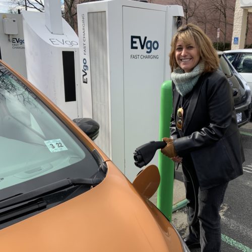 Pam Frank, CEO of ChargEVC, drives a bright Orange Chevrolet Bolt because she wants others to notice its an electric car. Jeff Brady/NPR