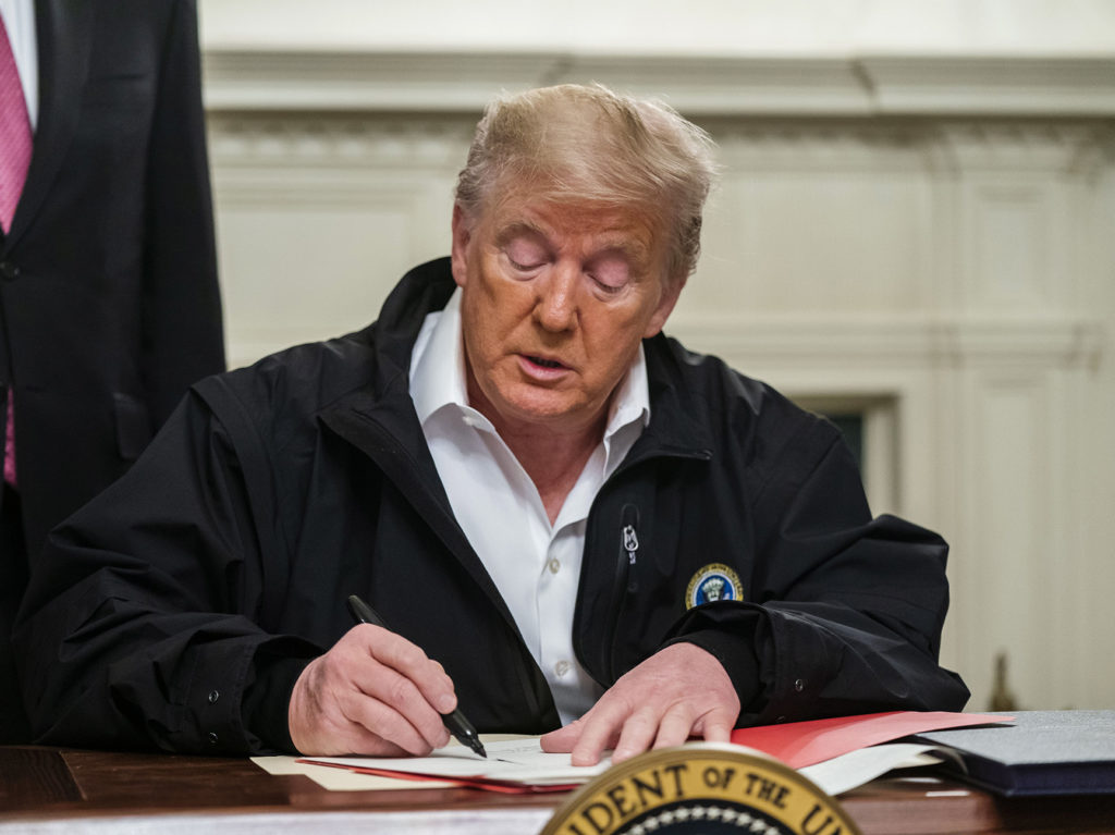 President Trump signs an $8.3 billion emergency spending bill in the White House Friday. That's significantly more than he originally requested from Congress. CREDIT: Jim Lo Scalzo/EPA/Bloomberg via Getty Images