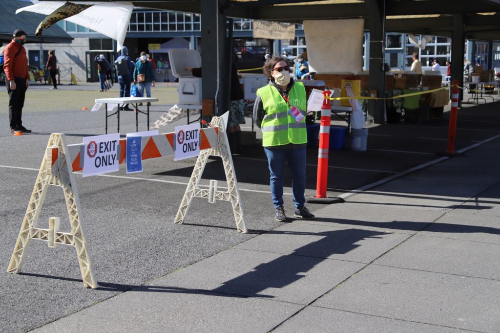 Bellingham Farmers Market board member Barbara Govednik monitors the new market exit to limit the number of people in the market so that physical distancing is maintained at all times. CREDIT: Washington State Farmers Market Association