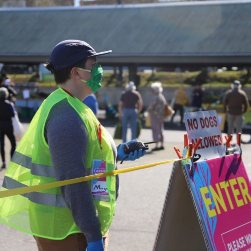 Morgan Henry Kerr of Bellingham's Farmers Market monitors the new market entrance to monitor the number of people in the market so that physical distancing is maintained at all times.