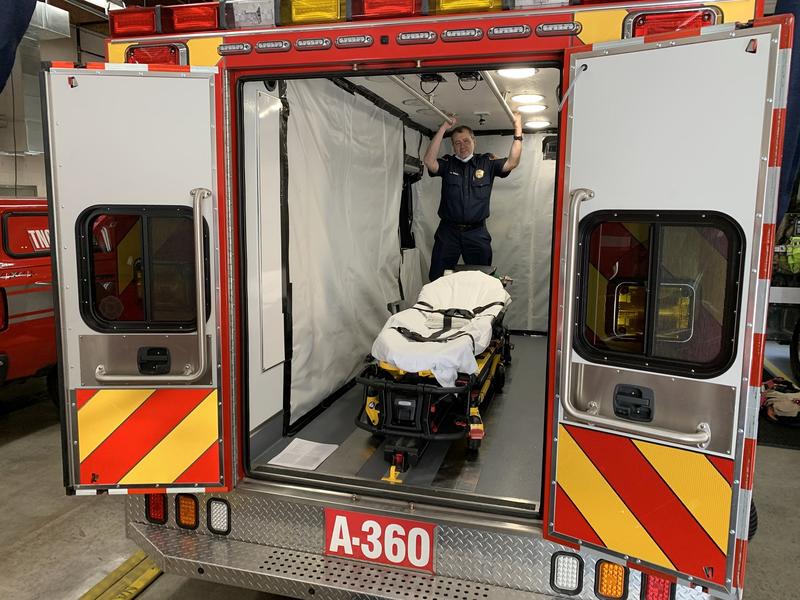 South King Fire and Rescue Lt. Greg Willett stands in an aid car optimized to transport COVID-positive patients.