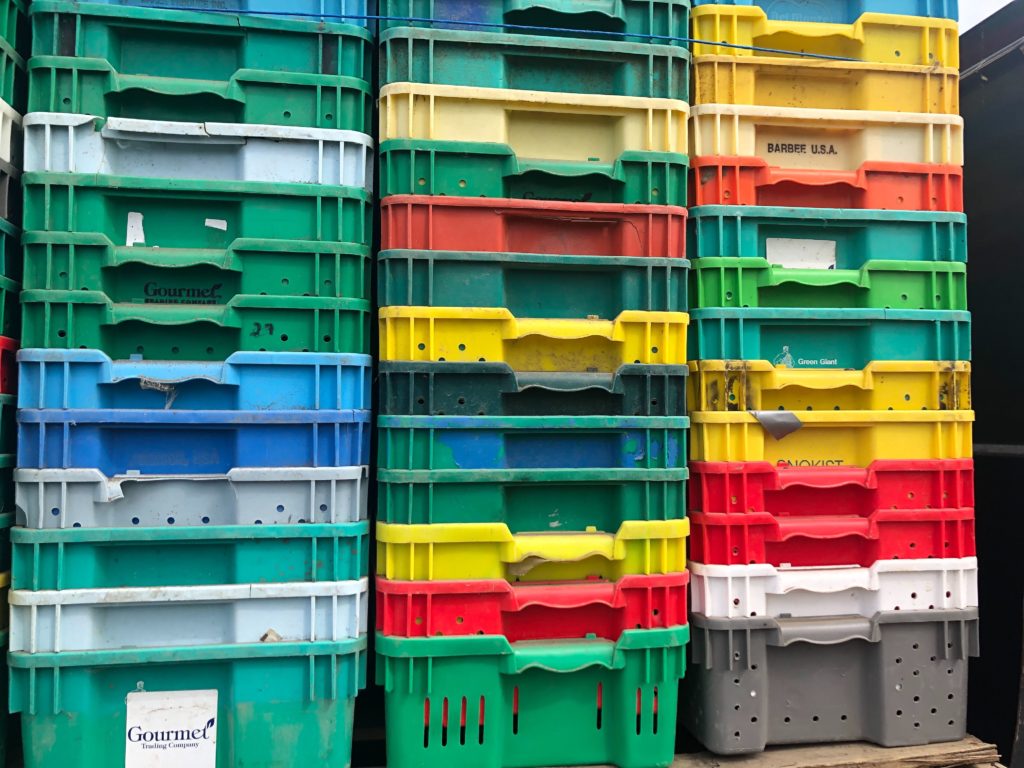Stacked like colorful LEGOs, plastic boxes called lugs will soon be filled with more than 25 pounds of asparagus each when harvest in the Northwest begins in a few days. CREDIT: Anna King/N3