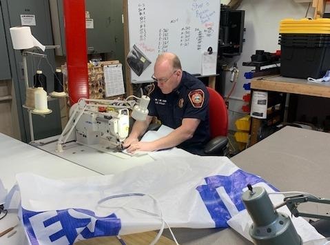 Driver-Engineer Jim Wilson sews a Tyvek gown at a Federal Way, Washington, fire station.