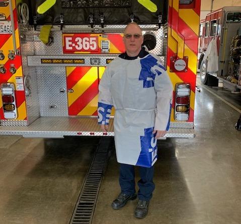Firefighter Jim Wilson models a protective gown he made out of construction-grade vapor barrier.