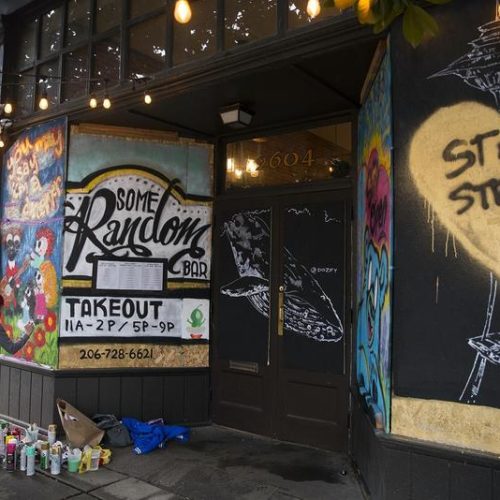 Shavonne Maes paints a mural onto the boarded up facade of Some Random Bar on March 26, 2020, in Seattle.