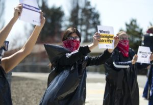 Giselle Uribe-Sayah, 15, wears a garbage bag and handkerchief while joining a nationwide protest demanding PPE for healthcare workers on Thursday, April 9, 2020, outside of Evergreen Health in Monroe. CREDIT: Megan Farmer/KUOW