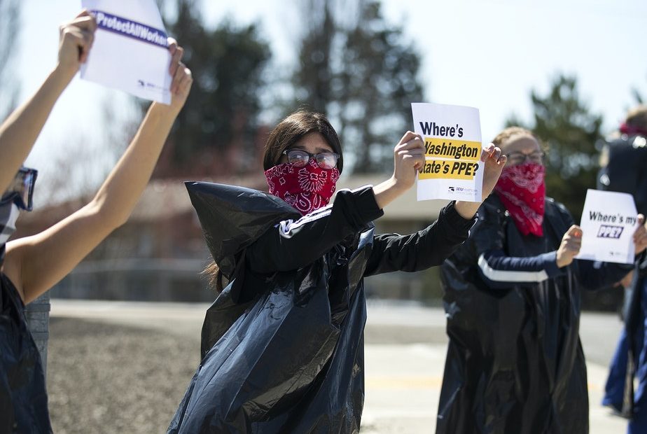 Giselle Uribe-Sayah, 15, wears a garbage bag and handkerchief while joining a nationwide protest demanding PPE for healthcare workers on Thursday, April 9, 2020, outside of Evergreen Health in Monroe. CREDIT: Megan Farmer/KUOW