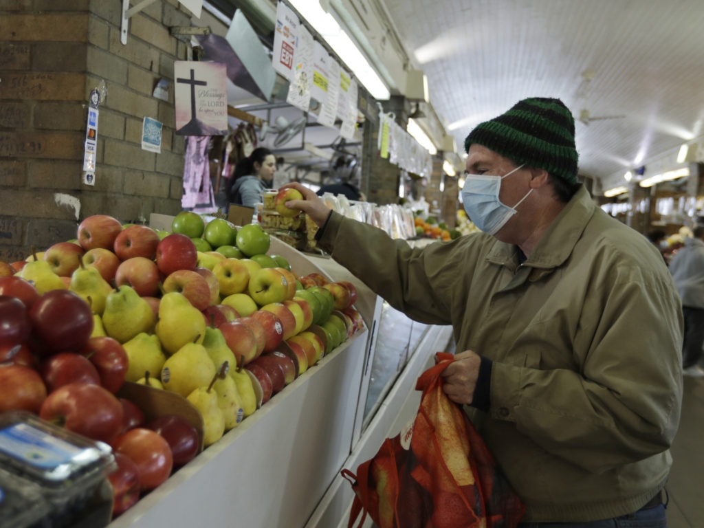 Rick Wittenmyer shops for groceries at the West Side Market, Friday, April 10, 2020, in Cleveland. There were fewer shoppers this year before the Easter holiday than in previous years due to the coronavirus. CREDIT: Tony Dejak/AP