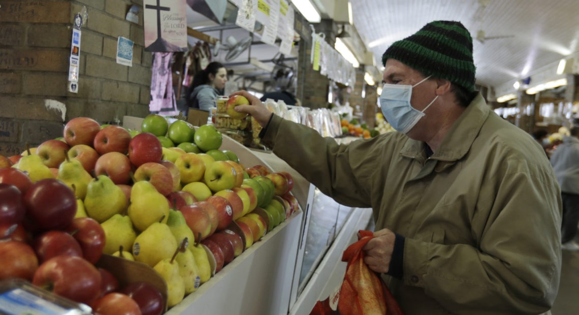Rick Wittenmyer shops for groceries at the West Side Market, Friday, April 10, 2020, in Cleveland. There were fewer shoppers this year before the Easter holiday than in previous years due to the coronavirus. CREDIT: Tony Dejak/AP