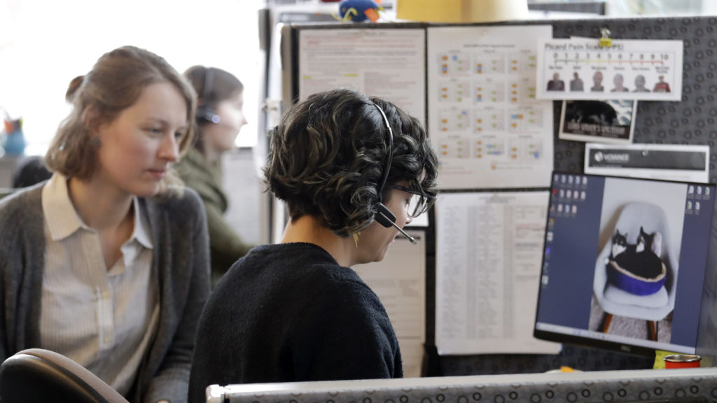 Washington says it will launch contact tracing teams to map coronavirus exposure. Here, public health nurse Jennifer Morgan, right, checks-in via phone with a patient self-quarantined at home in February. University of Washington epidemiology student Erika Feutz observes in Seattle. CREDIT: Elaine Thompson/AP