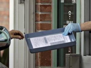 A County Library employee hands unemployment paperwork to residents in Tampa, Fla.