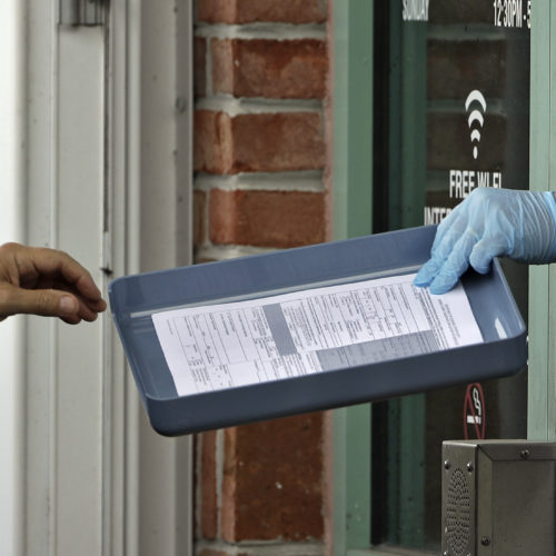 A County Library employee hands unemployment paperwork to residents in Tampa, Fla.