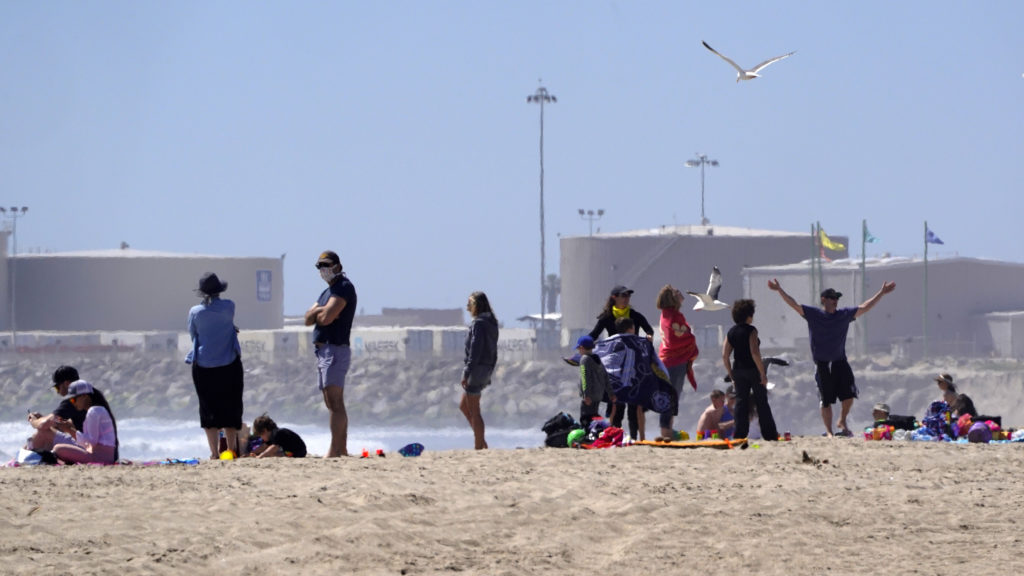 Beachgoers return to Port Hueneme Beach, Calif., on Thursday. Ventura County beaches and parks have been scheduled to reopen this week with some restrictions. CREDIT: Mark J. Terrill/AP