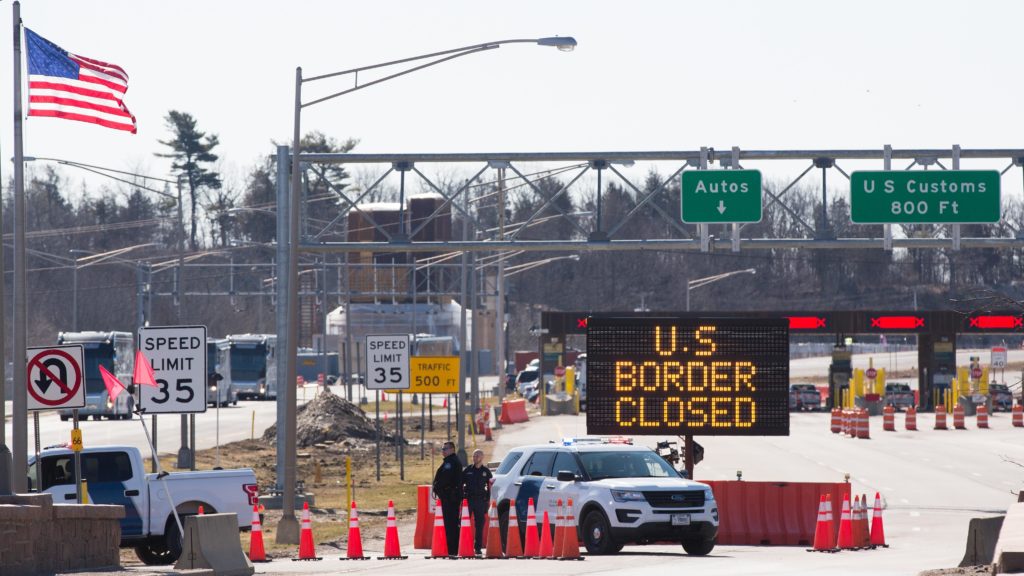 Customs officers stand beside a sign saying the U.S. border is closed in Lansdowne, Ontario, on March 22. The United States agreed with Mexico and Canada to restrict nonessential travel because of the new coronavirus, outbreak. CREDIT: Lars Hagberg/AFP via Getty Images