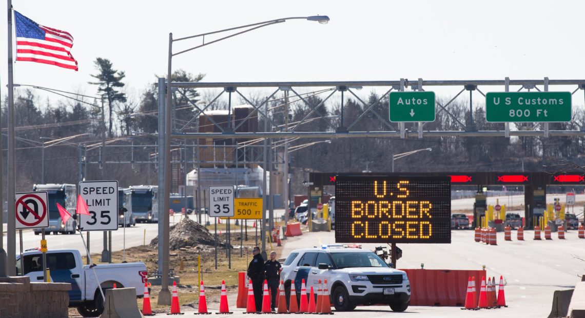 Customs officers stand beside a sign saying the U.S. border is closed in Lansdowne, Ontario, on March 22. The United States agreed with Mexico and Canada to restrict nonessential travel because of the new coronavirus, outbreak. CREDIT: Lars Hagberg/AFP via Getty Images