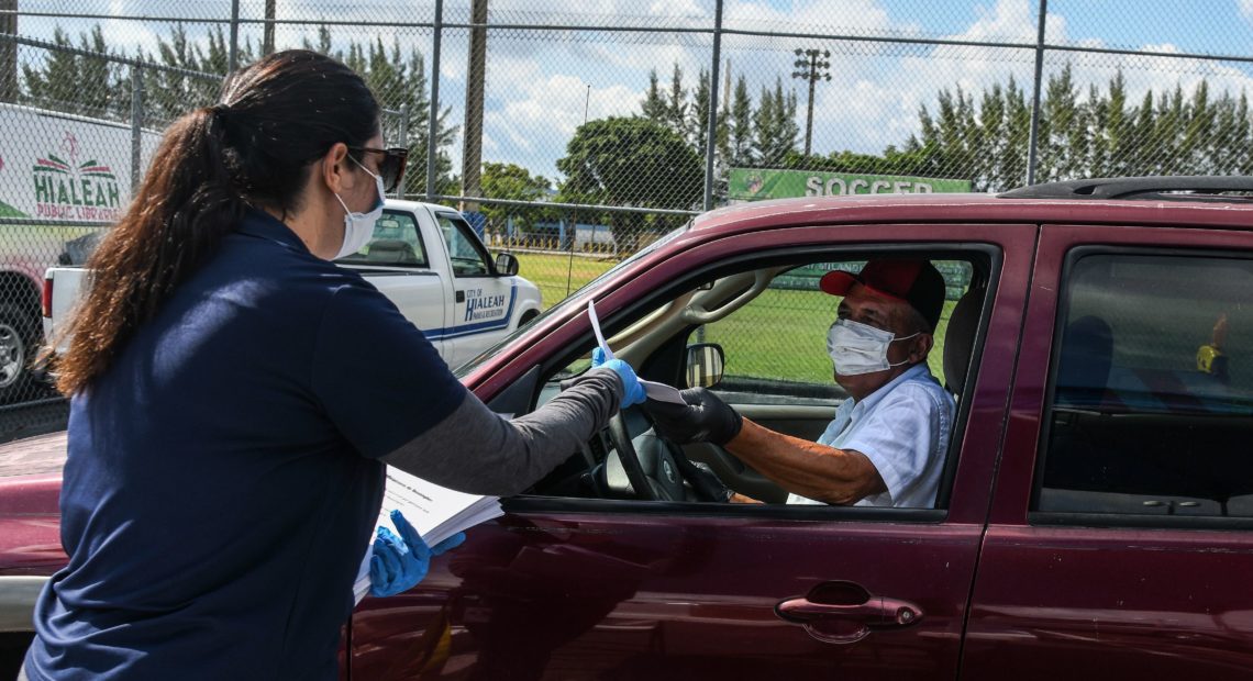 A man collects unemployment forms at a drive-through collection point outside of a library in Hialeah, Fla., on Wednesday. CREDIT: Chandan Khanna/AFP via Getty Images