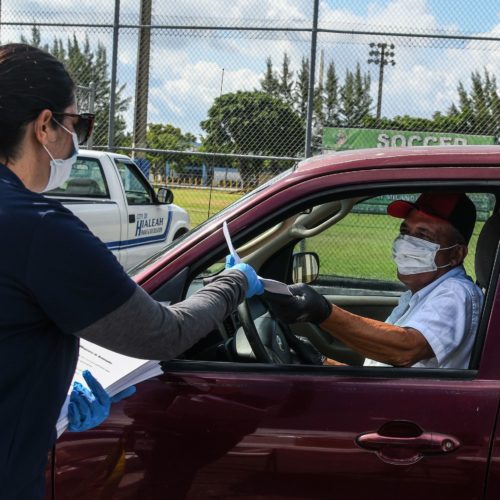 A man collects unemployment forms at a drive-through collection point outside of a library in Hialeah, Fla., on Wednesday. CREDIT: Chandan Khanna/AFP via Getty Images