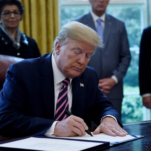 President Trump a new coronavirus economic aid package, largely targeted to support small businesses, in the Oval Office on Friday. CREDIT: Olivier Douliery/AFP via Getty Images