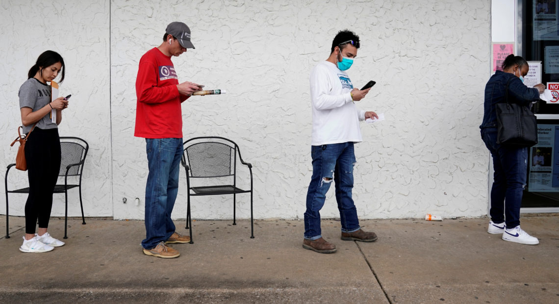 People who lost their jobs wait in line to file for unemployment benefits at an Arkansas Workforce Center in Fayetteville, Ark., on April 6. CREDIT: Nick Oxford/Reuters